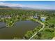 Expansive aerial view of a tranquil lake surrounded by lush greenery and a vibrant community, set against a mountain backdrop at 1270 Berea Dr, Boulder, CO 80305