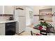 Bright kitchen with white appliances, white cabinets and dining table with decorative fruit-themed wallpaper at 1270 Berea Dr, Boulder, CO 80305