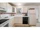 Well-lit kitchen featuring white cabinets, black dishwasher, and a window with a pleasant view at 1270 Berea Dr, Boulder, CO 80305