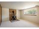 Spacious living room with a stone fireplace, large window, and carpet flooring at 1270 Berea Dr, Boulder, CO 80305