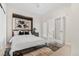 Bright bedroom boasts modern artwork, neutral tones, and sun-filled double doors to a private balcony at 2530 Lawrence St # Ra101, Denver, CO 80205