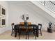 Minimalist dining area with black dining set under staircase, complemented by stylish decor and natural light at 2530 Lawrence St # Ra101, Denver, CO 80205