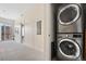 Convenient laundry area featuring stacked washer and dryer units, maximizing space in the hallway at 2530 Lawrence St # Ra101, Denver, CO 80205