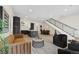 Bright, open-concept living room with modern furniture and a view of the kitchen and staircase at 2530 Lawrence St # Ra101, Denver, CO 80205