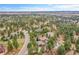 Beautiful home nestled amongst trees with a view of distant plains under a partly cloudy sky at 5449 Songbird Way, Parker, CO 80134