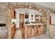 Charming bar area with custom wood cabinetry, granite countertops, and stone archway detail at 5449 Songbird Way, Parker, CO 80134