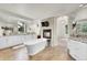 Bright bathroom with a soaking tub, stone fireplace, double vanity, and modern finishes at 5449 Songbird Way, Parker, CO 80134