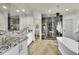 Luxurious bathroom featuring a soaking tub, granite vanity, tiled floors and glass shower at 5449 Songbird Way, Parker, CO 80134