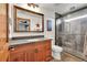 Modern bathroom with a wood vanity, a large mirror, and a glass-enclosed shower at 5449 Songbird Way, Parker, CO 80134