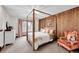 Elegant bedroom featuring a four-poster bed, wood accent wall, and soft natural light at 5449 Songbird Way, Parker, CO 80134