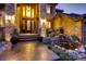Elegant front entrance with stone accents, decorative lighting, and a charming water feature at 5449 Songbird Way, Parker, CO 80134