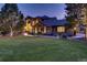 Beautiful exterior home elevation featuring manicured lawn, stone accents, and accent lighting at 5449 Songbird Way, Parker, CO 80134