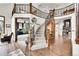 Grand foyer boasts a curved staircase, hardwood floors, and views into multiple living spaces at 5449 Songbird Way, Parker, CO 80134