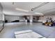 Spacious garage with storage, a lawnmower, a work bench and staircase at 5449 Songbird Way, Parker, CO 80134