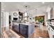 Open concept kitchen featuring a large island, wood floors, and views of the dining area at 5449 Songbird Way, Parker, CO 80134