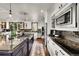 Bright kitchen features granite countertops, stainless appliances, hardwood floors, and kitchen island with cooktop at 5449 Songbird Way, Parker, CO 80134