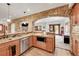 Convenient kitchenette with stainless steel appliances, stone arch, and wood cabinets at 5449 Songbird Way, Parker, CO 80134