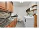 Well-organized laundry room with front loading washer and dryer, ample cabinetry and tile backsplash at 5449 Songbird Way, Parker, CO 80134