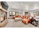 Open living room with stone fireplace, large windows, and a comfortable leather sectional sofa at 5449 Songbird Way, Parker, CO 80134