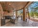 Inviting covered patio with wood ceiling, stone columns, a hot tub, and ample seating at 5449 Songbird Way, Parker, CO 80134