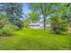 Lush backyard featuring a lawn, mature trees, and a patio with a staircase, creating a private retreat at 1715 Alkire St, Golden, CO 80401