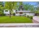 Charming home with a well-maintained lawn, mature trees, and a brick facade at 1715 Alkire St, Golden, CO 80401