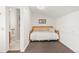 Neutral bedroom with carpeting and trundle bed adjacent to a bathroom with all white walls at 6480 W 60Th Ave, Arvada, CO 80003
