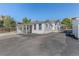 Exterior view of a charming white home with an extended driveway, fenced yard, and mature trees at 6480 W 60Th Ave, Arvada, CO 80003