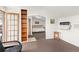Cozy living room with access to a bedroom, featuring built in shelving and neutral brown carpeting at 6480 W 60Th Ave, Arvada, CO 80003