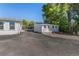 Rear view of outbuilding and adjacent parking, next to mature trees and landscaping at 6480 W 60Th Ave, Arvada, CO 80003