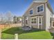 Back of the house with artificial turf, gray siding, a flagstone patio, and white trim at 16564 High Desert Way, Parker, CO 80134
