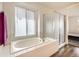 Bright bathroom featuring a soaking tub, glass shower, large window and vinyl flooring at 16564 High Desert Way, Parker, CO 80134