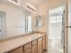 Functional bathroom featuring a single sink vanity, a large mirror, and vinyl flooring at 16564 High Desert Way, Parker, CO 80134