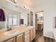Well-lit bathroom featuring a double sink vanity, large mirror, and vinyl flooring at 16564 High Desert Way, Parker, CO 80134