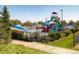 Community pool area featuring a tall waterslide, pool, recreational area, and lush landscaping at 16564 High Desert Way, Parker, CO 80134