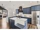 Bright kitchen with a large island, stainless steel appliances, custom cabinets, and a view to the living area at 16564 High Desert Way, Parker, CO 80134