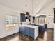 Modern kitchen showcasing a quartz countertop island, custom hood, blue cabinets, and stainless steel appliances at 16564 High Desert Way, Parker, CO 80134