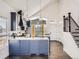 Bright kitchen boasts blue cabinets, a marble island, stainless appliances, and pendant lights at 16564 High Desert Way, Parker, CO 80134