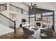 Open living room with a fireplace, high ceilings, a cozy layout, and a connection to the second-floor landing at 16564 High Desert Way, Parker, CO 80134