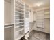 Organized walk-in closet featuring white shelving, drawers, and carpeted flooring at 16564 High Desert Way, Parker, CO 80134