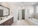 Bathroom featuring a double vanity, soaking tub, and large glass enclosed shower at 2495 S Madison St, Denver, CO 80210