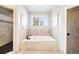 Bright bathroom with a soaking tub, tiled walls, and separate shower area at 2495 S Madison St, Denver, CO 80210