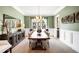 Elegant dining room with a long wooden table, stylish chairs, and ample natural light at 2495 S Madison St, Denver, CO 80210