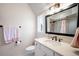Well-lit bathroom featuring modern fixtures, a framed mirror, and neutral tones at 2495 S Madison St, Denver, CO 80210