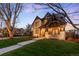 Stunning exterior evening shot of a two-story home featuring stone accents and manicured landscaping at 2495 S Madison St, Denver, CO 80210