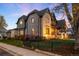 Exterior elevation showcases a sophisticated Tudor home with a manicured lawn, stone, and brick finishes at 2495 S Madison St, Denver, CO 80210