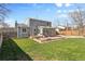 Grassy backyard with patio, grill, and a view of the home featuring a sunroom at 4860 S Field Way, Littleton, CO 80123
