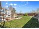 A well manicured backyard with green grass, trees, a grill, and a deck at 4860 S Field Way, Littleton, CO 80123