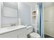 Bathroom with white vanity, built in shelving, toilet, mirror, and a shower with colorful curtain at 4860 S Field Way, Littleton, CO 80123