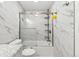Full white tub shower with modern gray marbled tile from floor to ceiling with shower rack at 4860 S Field Way, Littleton, CO 80123